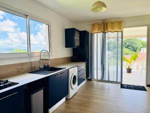 a kitchen with a sink and a washing machine at Sweety blue, vue mer in Les Trois-Îlets