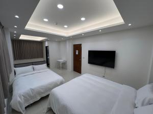 a hotel room with two beds and a flat screen tv at 荷民宿 HO Homestay in Yuanshan