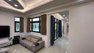 a living room with a couch and a flat screen tv at 荷民宿 HO Homestay in Yuanshan +4 photos