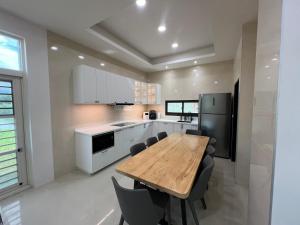 a kitchen with a wooden table and some chairs at 荷民宿 HO Homestay in Yuanshan
