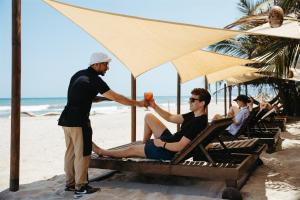 a man shaking another mans hand on the beach at Bohemia Beach Tayrona in Guachaca