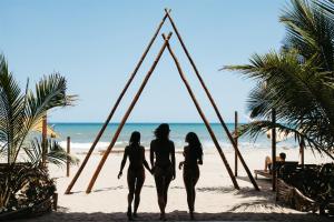 three girls in bathing suits walking on the beach at Bohemia Beach Tayrona in Guachaca