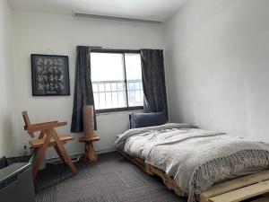 a bedroom with a bed and a window at Chill House in Myoko