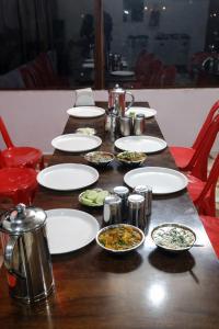 a wooden table with plates of food on it at shiv shankar resort and hotel in Phata +9 photos