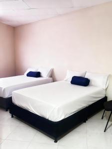 two beds sitting next to each other in a room at Hotel Plaza de Toros in Manizales +9 photos