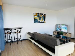 a living room with a couch and a table at Sweety blue, vue mer in Les Trois-Îlets