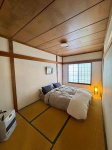 a bedroom with a bed in the corner of a room at Chill House in Myoko