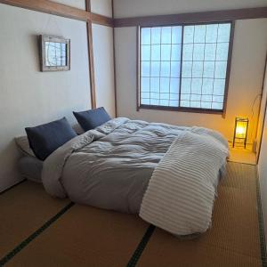 a bed in a bedroom with a large window at Chill House in Myoko +1 photo