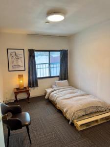 a bedroom with a large bed and a window at Chill House in Myoko