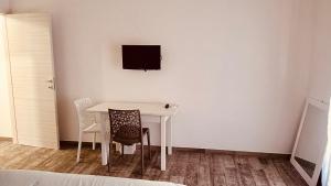 a white table with two chairs and a television on a wall at Art home Amalfi coast in Salerno +8 photos