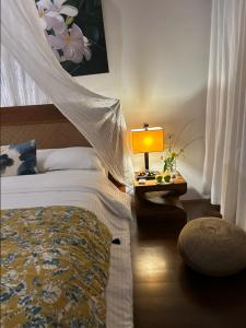 ein Schlafzimmer mit einem Bett und einem Tisch mit einer Lampe in der Unterkunft palay in Cabulihan
