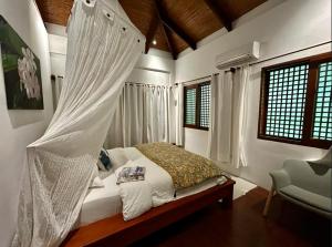 ein Schlafzimmer mit einem Bett mit Moskitonetz in der Unterkunft palay in Cabulihan + 9 Fotos