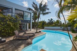 a swimming pool with two chairs and a house at Luxury Retreat with Pool & Views in São Roque