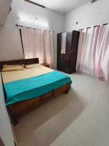 a bedroom with a bed with blue sheets and a window at Cozy Nest in Pūvār +4 photos