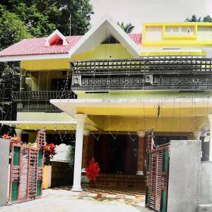 a yellow house with a red roof at Cozy Nest in Pūvār