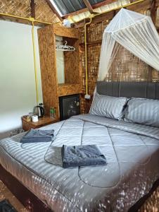 a bedroom with a bed with a mosquito net on it at Bansuan Lanta Maikaew in Ko Lanta