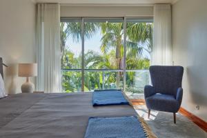 a bedroom with a large bed with a chair and a window at Luxury Retreat with Pool & Views in São Roque +47 photos