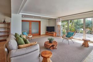 a living room with a couch and a tv at Luxury Retreat with Pool & Views in São Roque
