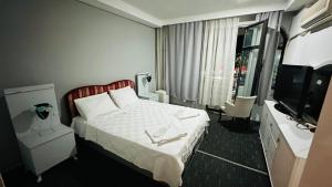 a hotel room with a bed and a television at Sürücü oteli in Milas