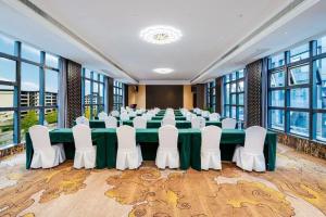 a conference room with a long table and white chairs at 泽润大酒店 in Chengdu