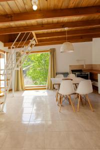 a living room with a staircase and tables and chairs at An Dina House in Dina Huapi