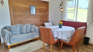 a living room with a table and a couch at Hospedaria Brigite - Apartamento de Férias in Treze Tílias