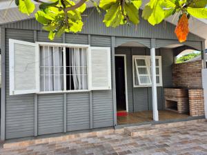 a house with a garage door and two windows at Casa Chalé Ilha Comprida in Ilha Comprida
