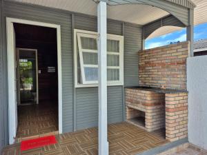 a porch of a house with a brick fireplace at Casa Chalé Ilha Comprida in Ilha Comprida
