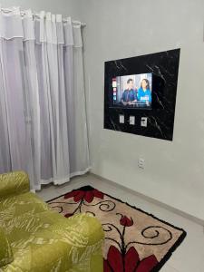 a living room with a tv on the wall at Apartamento Aconchego II in Alta Floresta