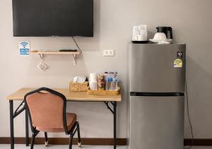 a desk with a refrigerator and a table with a chair at MBB House in Thalang
