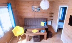 a living room with a couch and a table at AIDA Domki Letniskowe - domki 5 min od MORZA - Plac Zabaw & ANIMACJE dla DZIECI, ROWERY gratis dla Gości in Rewal