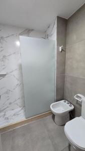 a white bathroom with a toilet and a sink at Departamento BARBÚ in Villa María +7 photos