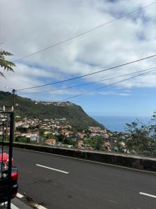 a road with a view of a city and the ocean at Casa do Arco in Arco da Calheta
