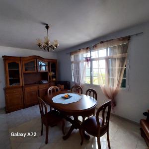 a dining room with a wooden table and chairs at Casa do Arco in Arco da Calheta