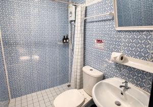 a bathroom with a shower and a toilet and a sink at MBB House in Thalang
