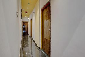 a hallway with a wooden door in a building at Hotel O Golden Suites in Turambhe