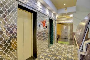 a lobby with a door and a tile wall at Hotel O Golden Suites in Turambhe
