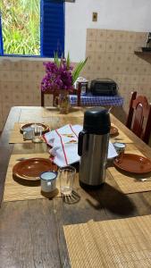 a table with plates and a tea kettle on it at Fazenda Brasileiro in Passos