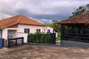 a white house with a gate and a fence at Fazenda Brasileiro in Passos