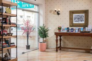 a shop with a table and potted plants in a room at Ness Hotel in Tel Aviv
