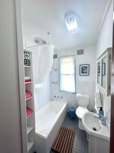 a bathroom with a tub and a toilet and a sink at Watson Street Cottage in Albury +4 photos