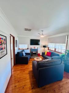 a living room with two couches and a table at Watson Street Cottage in Albury