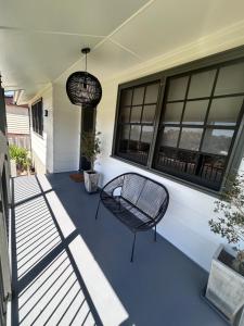 a porch with a bench and a window at Watson Street Cottage in Albury