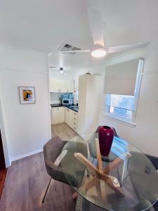 a living room with a glass table and a chair at Watson Street Cottage in Albury