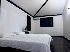 a bedroom with a white bed and a window at The Kasbo in Unawatuna