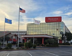 a building with flags in front of a parking lot at Ramada by Wyndham Tulsa Broken Arrow in Broken Arrow