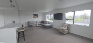 a living room with a couch and a chair at Beachfront Bliss in Snells Beach