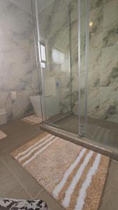 a bathroom with a shower and a rug at Beachfront Bliss in Snells Beach +5 photos