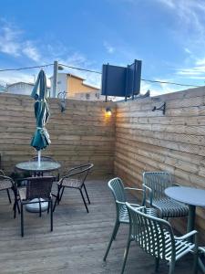 a patio with tables and chairs and a tv on a fence at GreeneStay Sindang DDP Seoul in Seoul