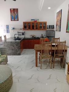 a kitchen with a table and some chairs and a table and a kitchen at Wyanna Villa LEGIAN in Legian